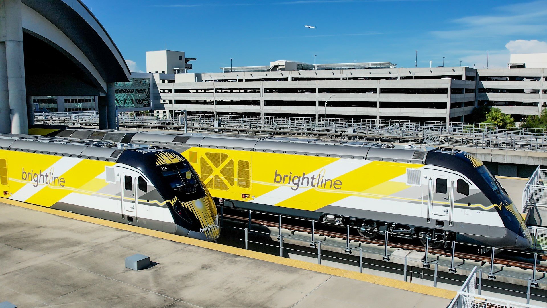 two brightline trains coming out of the station